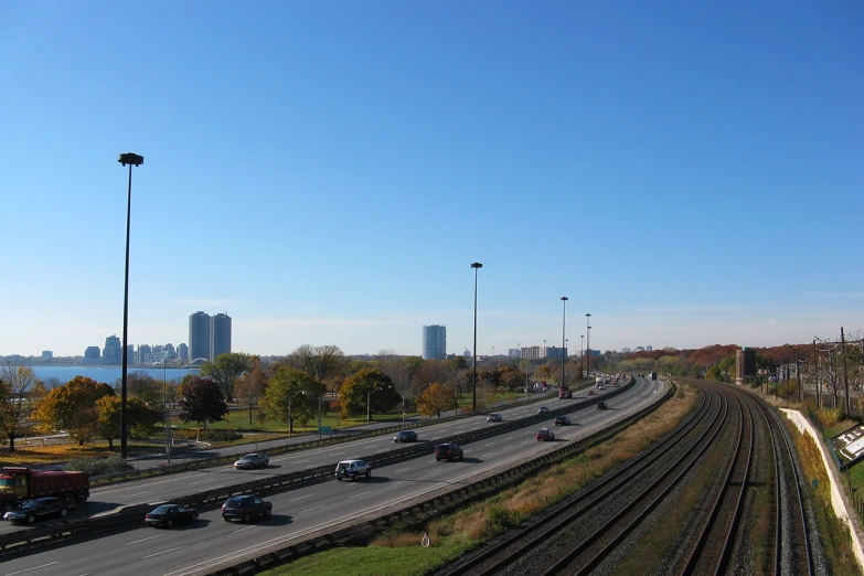 highway with buildings and train tracks in the background