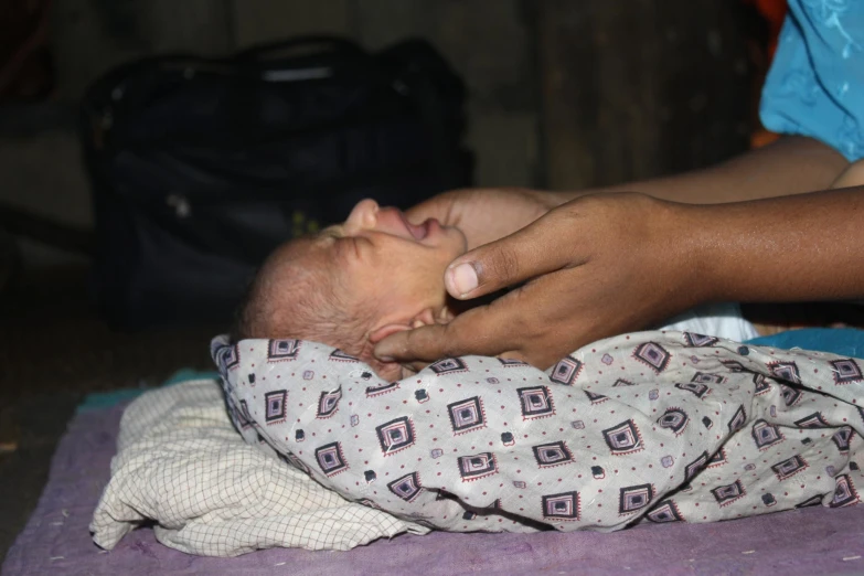 a small child sleeping while being held by the woman