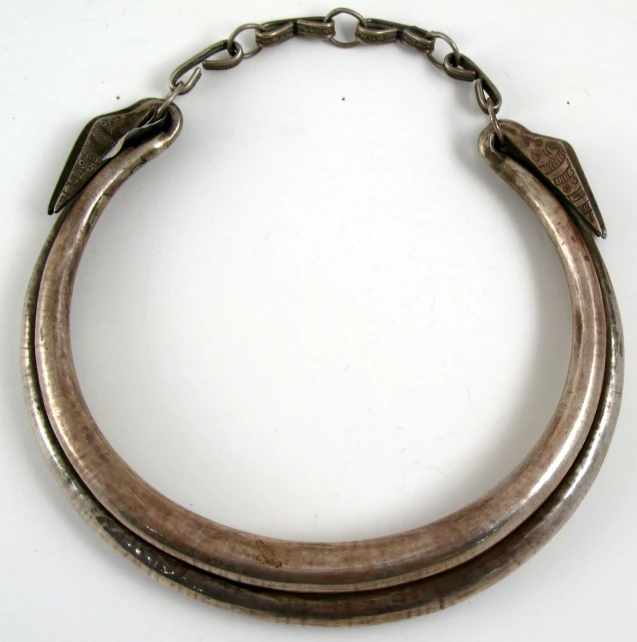 an odd shaped celet has a loop of metal links attached