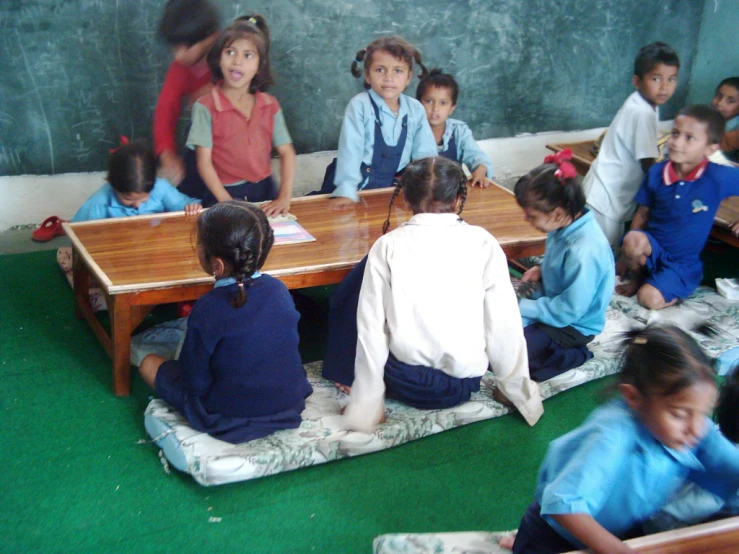 children in a classroom sitting on the ground