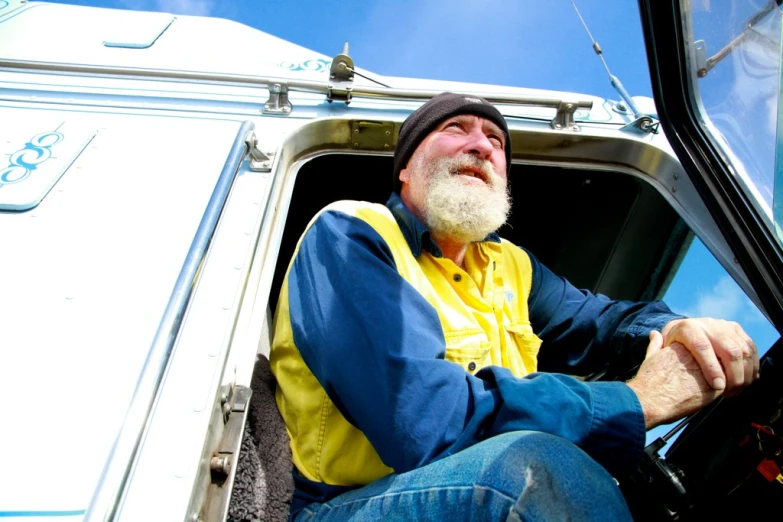 an older gentleman sits in the drivers seat of a van