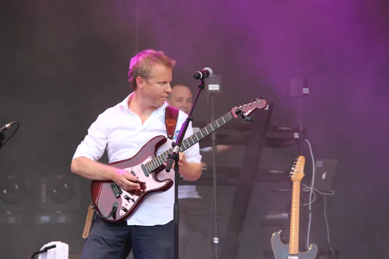 a man with an electric guitar on stage playing