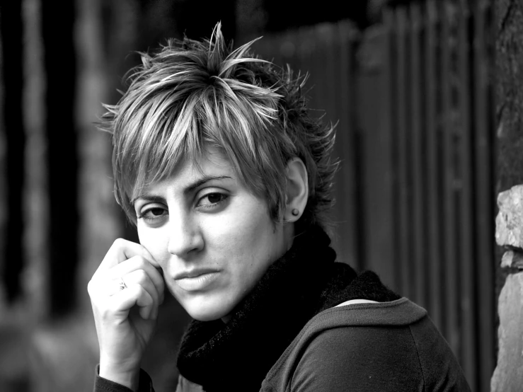 a woman standing on the side of a fence