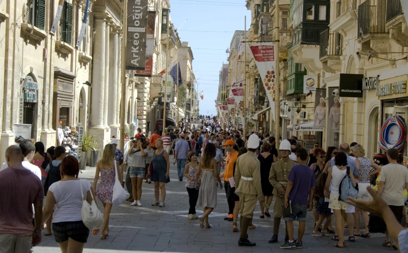 a crowd of people are walking through a city
