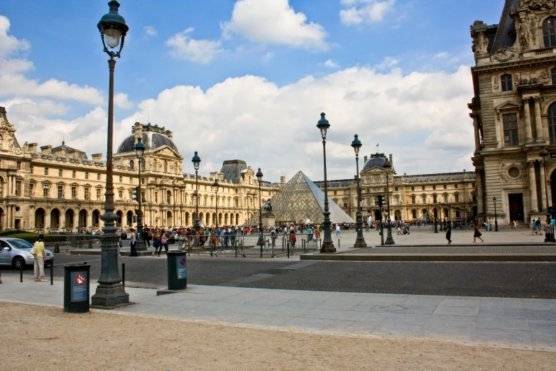 a crowd of people walking around in front of the pyramid