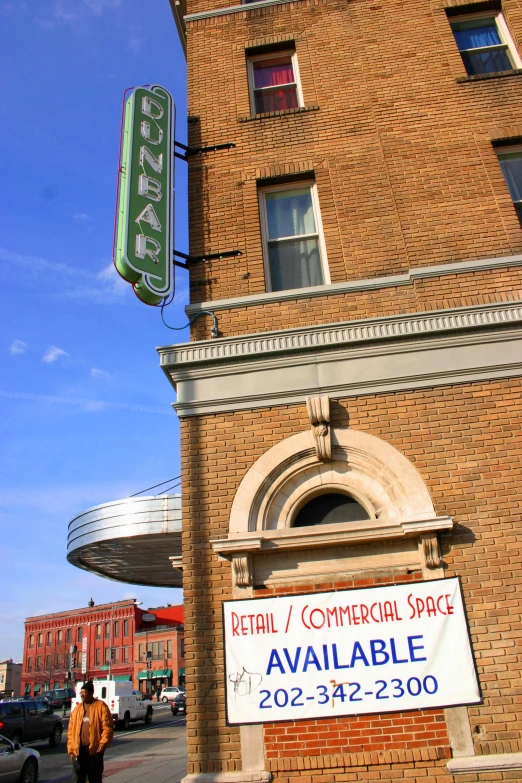 people walk past a large building that sells some sort of commercial space