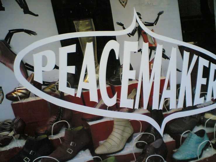 a sign with the words peacemakers is shown through a pile of shoes