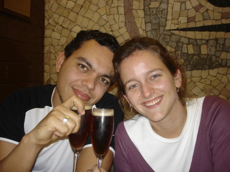 couple smiling while drinking from wine glasses