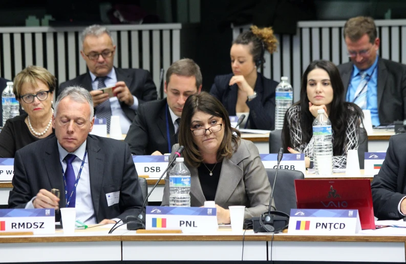 a group of people sitting at a desk in front of a man