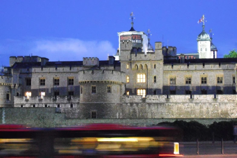 castle building with clock tower and double decker bus going by