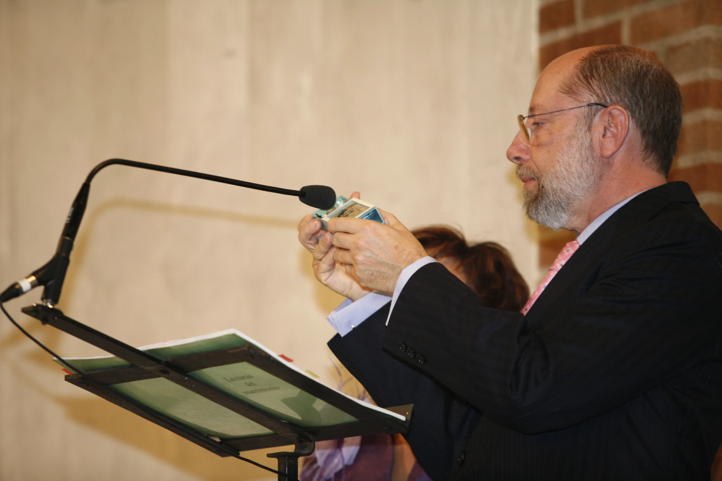 a man standing next to a microphone in front of a microphone stand