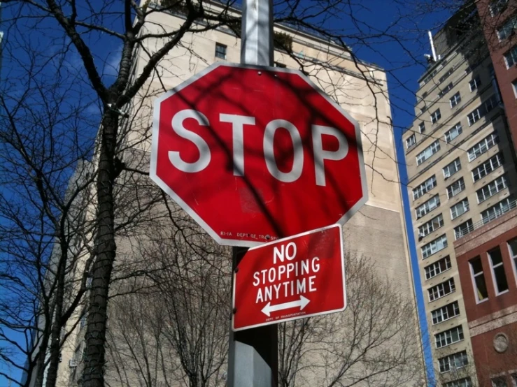 a stop sign stands tall between two other traffic signs
