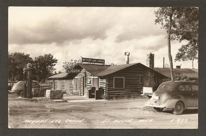 an old po of a small town with cars parked in front