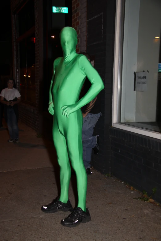 a man in a green suit stands outside of a building