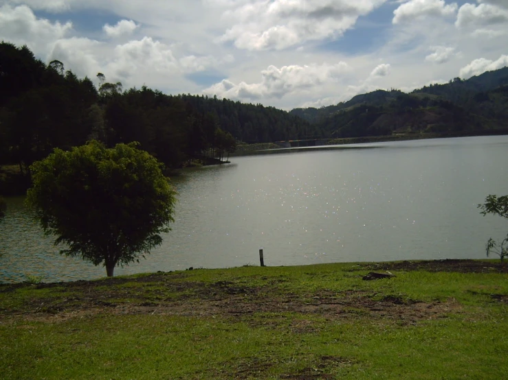 a scenic lake surrounded by mountains and green grass
