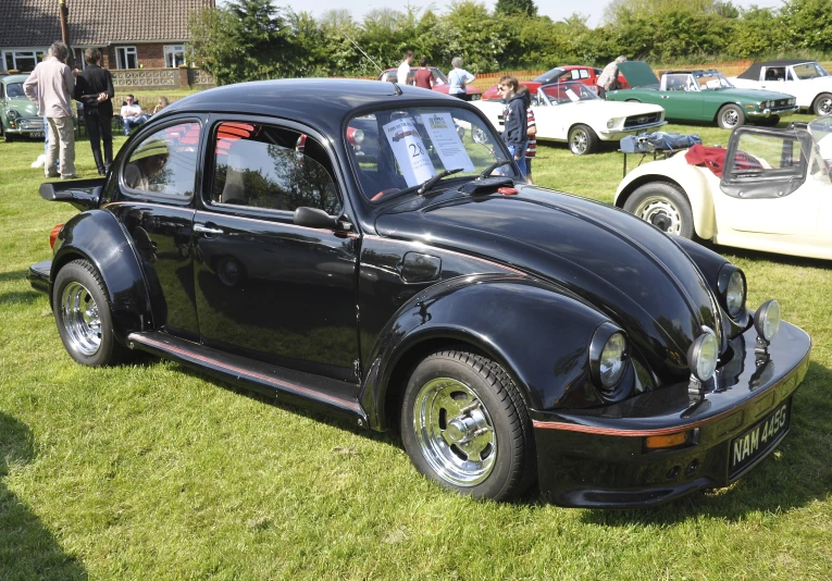 an antique black bug parked on a field