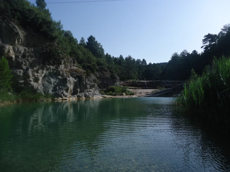 the water at the edge of a lake with a rocky bank