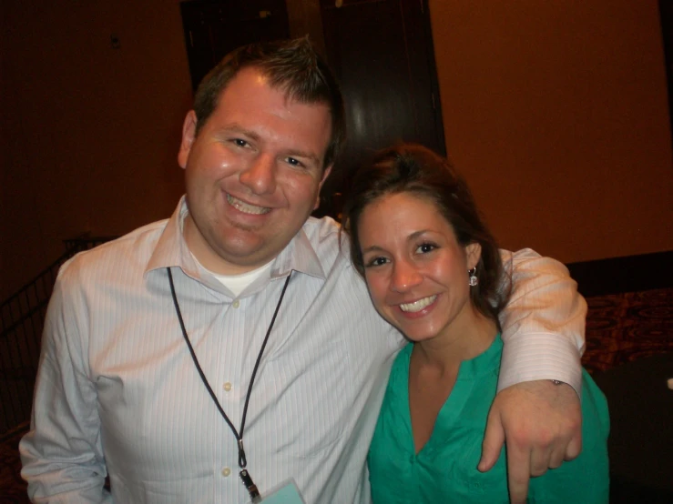 a man and woman with a peace sign pose for the camera