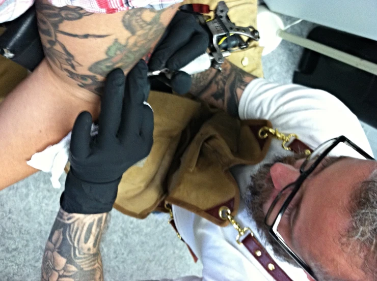 a tattooed man getting his hands done