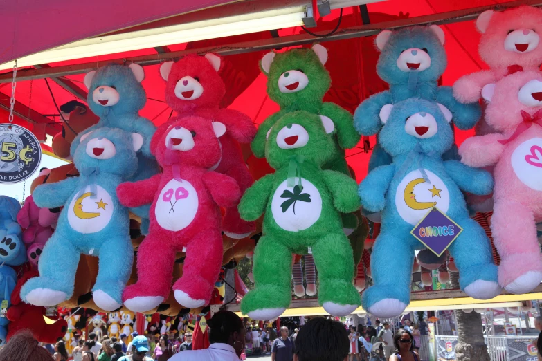 a row of stuffed animals hanging in an area under a canopy