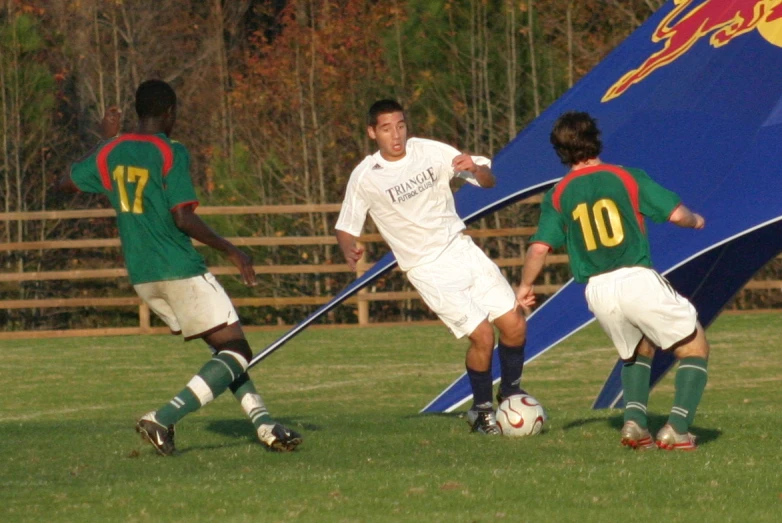 two boys playing a game of soccer on the grass