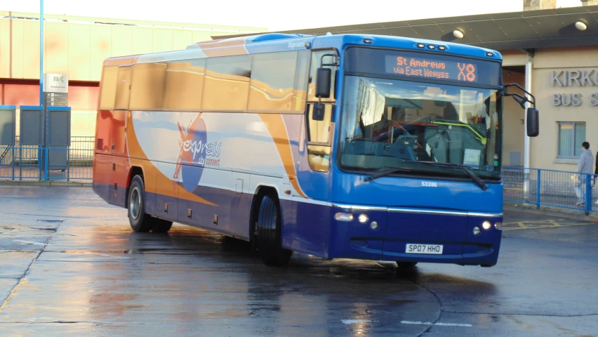 a blue and yellow bus that is on the street