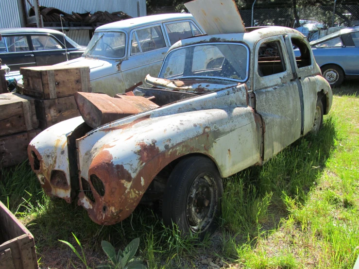 an old truck and some other vehicles are on the grass