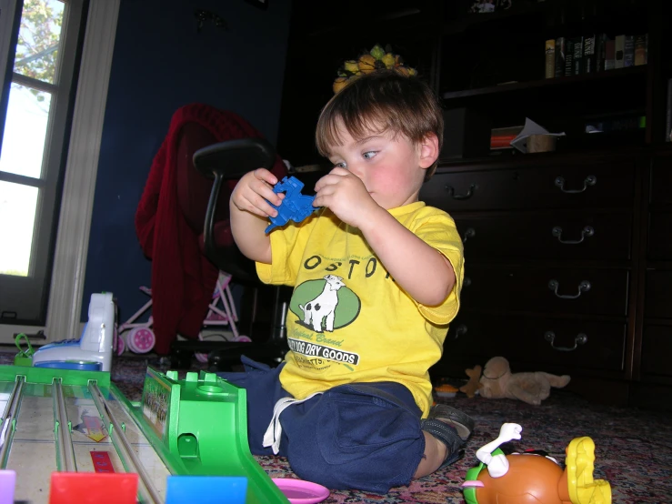 the small boy is playing with the toy train set