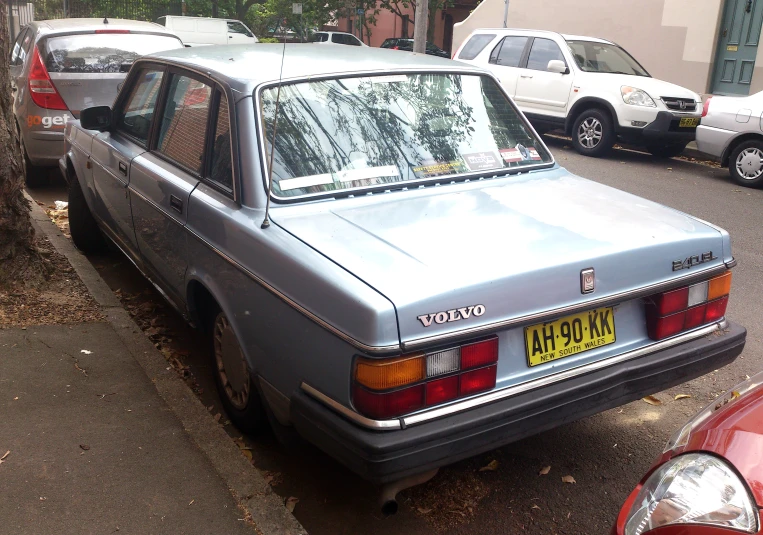 a grey car parked next to a tree