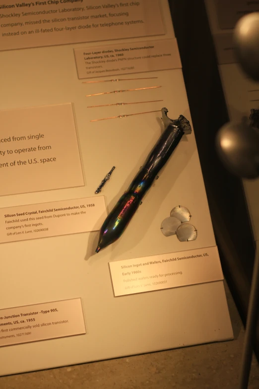 a pen on display with papers next to it