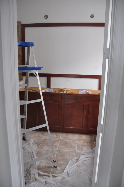 a ladder in an unfinished room with a mirror