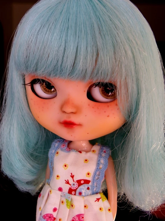 an adorable doll with long light blue hair