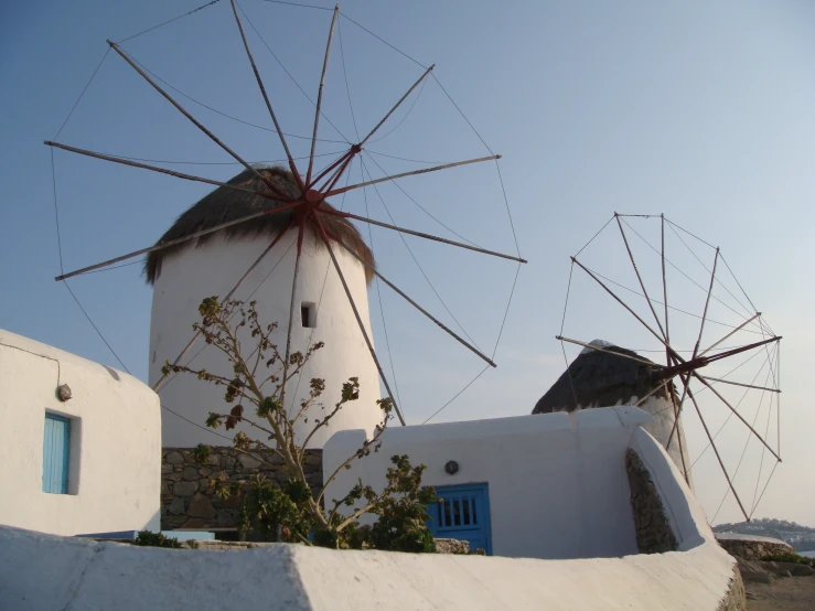 a white windmill with red spokes in front of a blue door