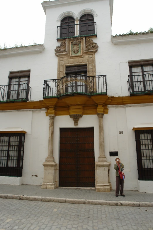 the front entrance to a building with a man and woman standing on the outside