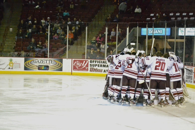 a group of hockey players huddle together for a moment to congratulate on their success