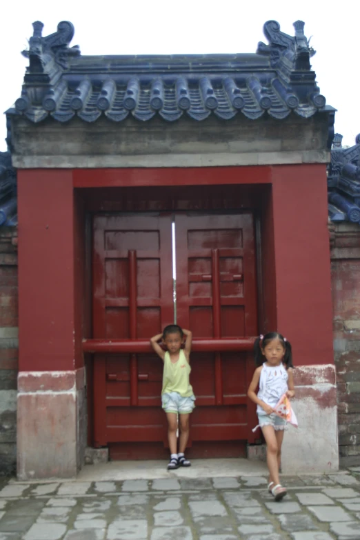 two small children with hands on doors