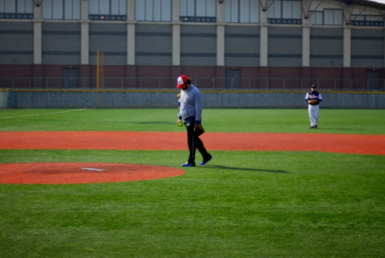 a man in a baseball uniform walks toward the pitcher's mound