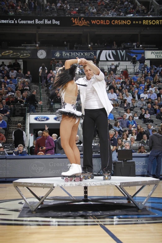 a couple performing stunts on a basketball court