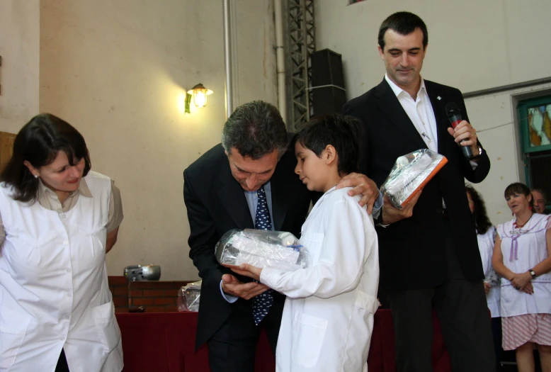 people are dressed in black, white and one is wearing a suit and the other is holding a bag