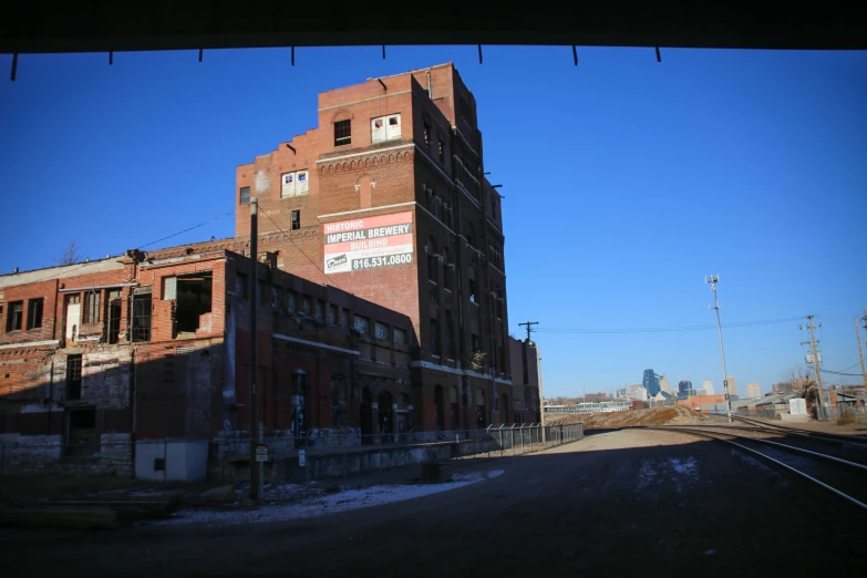 an old building next to train tracks on a sunny day