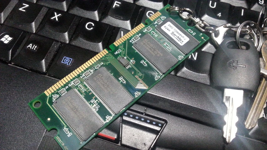 the key chain on top of a computer card is connected to a laptop keyboard