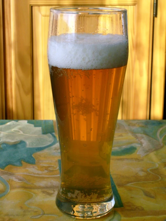 a full glass of beer sitting on top of a table