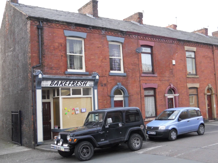 cars parked in front of an old brick bakery