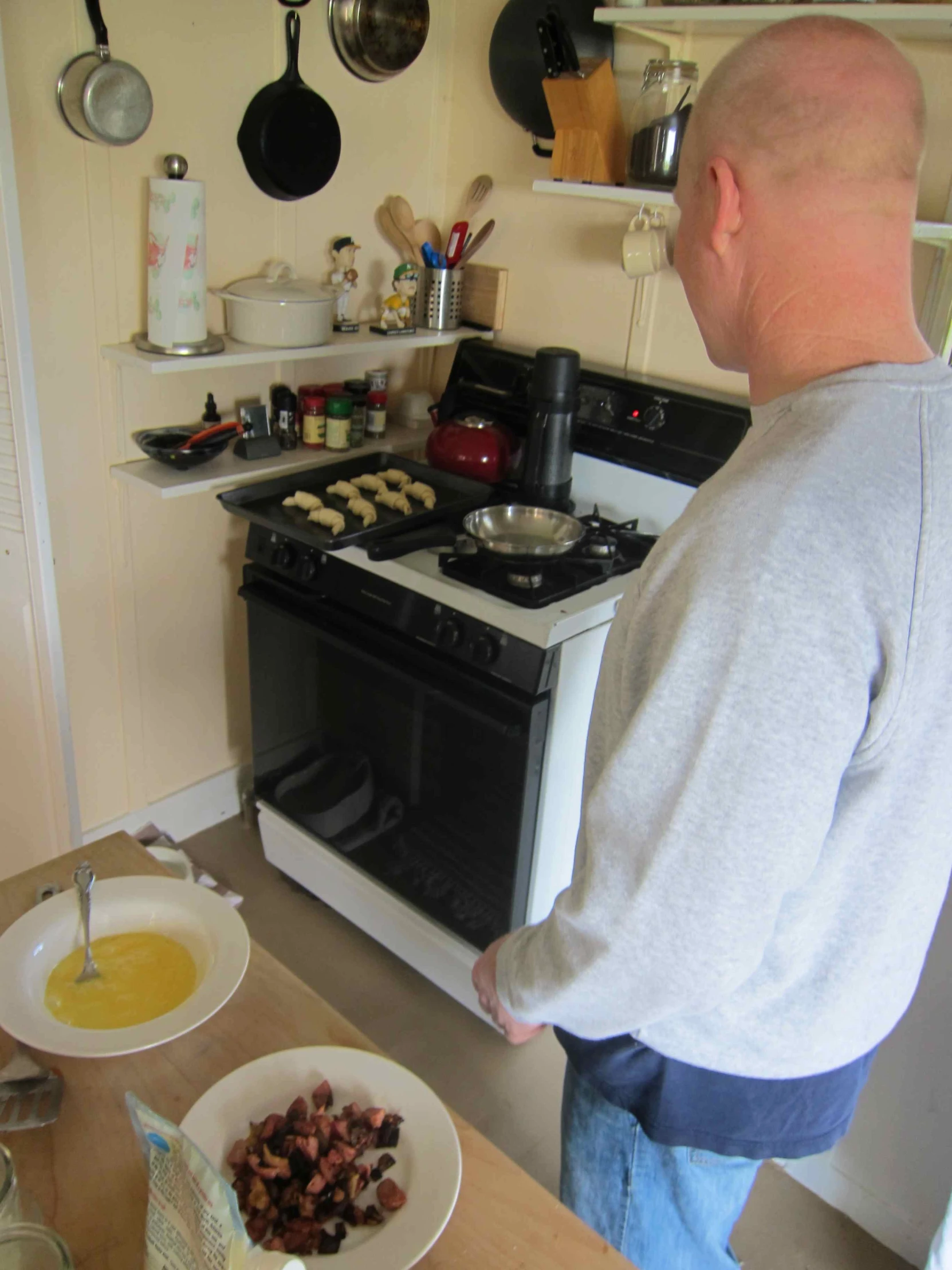 a man in grey sweater looking at a stove