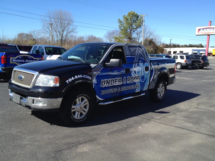 a truck sits in a parking lot near some other cars