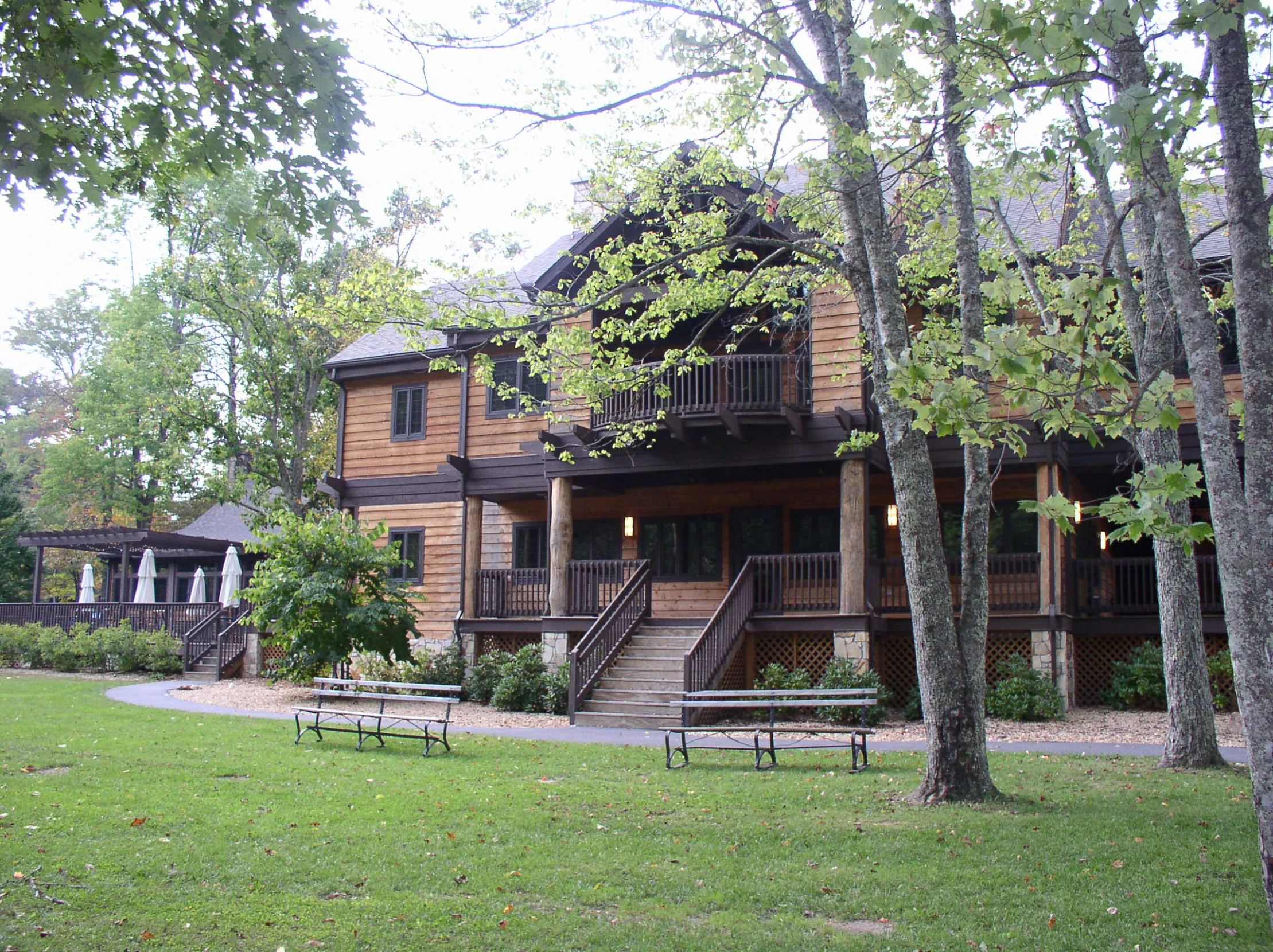 a two story house with multiple balconies and benches