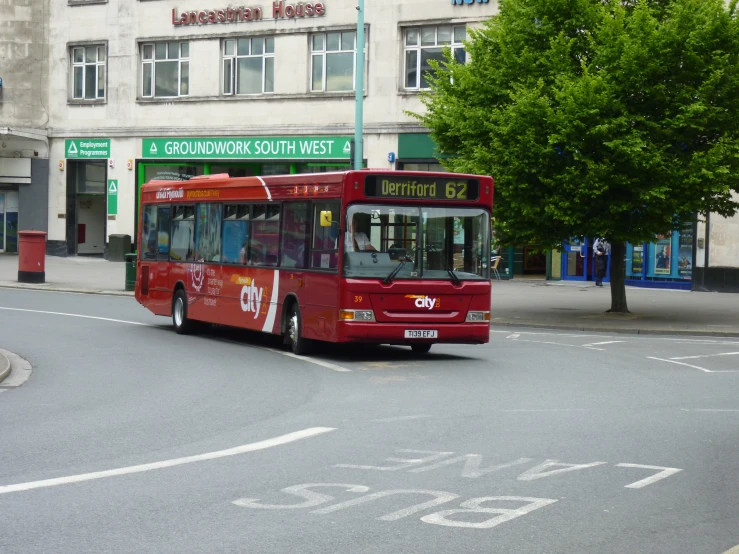 a red passenger bus driving through an intersection