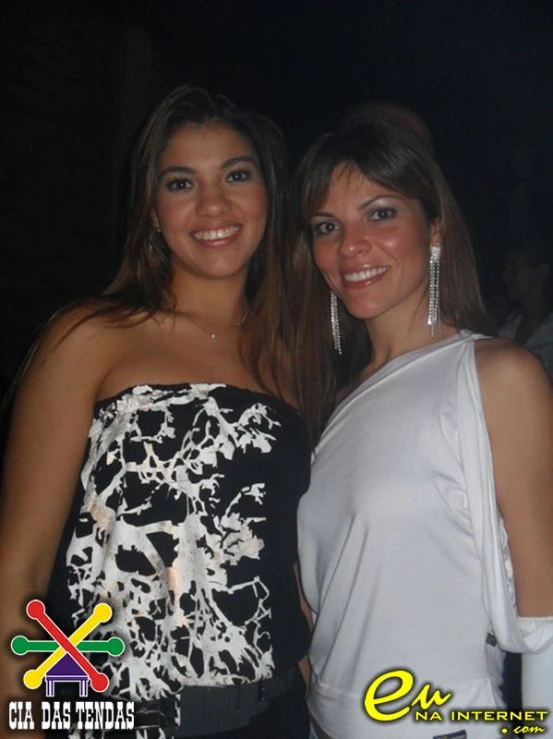 two girls standing beside one another smiling at the camera