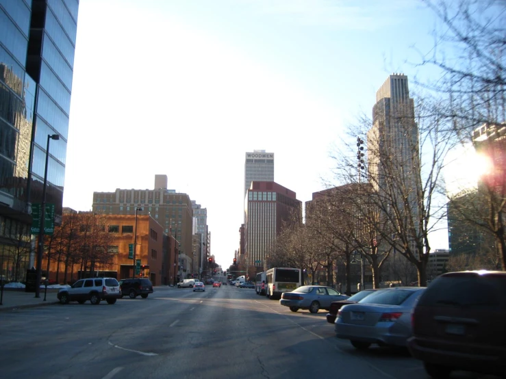 a group of cars are parked in front of tall buildings on a street