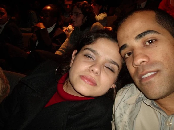 a couple posing for the camera on the front row of an auditorium